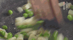 鍋中油7成熱時，入青豆、筍丁翻炒，然后加糯米飯加鹽均勻翻炒。