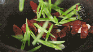 先后下香腸片、四季豆絲均勻翻炒，加適量清水燜煮一下。