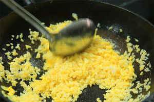 大火加熱炒鍋，再入油，燒到四至五成熱時(shí)倒入雞蛋液，在未凝結(jié)之前，加米飯煸炒，不停翻炒并用鍋鏟將成塊的米飯碾開(kāi)、撥散。