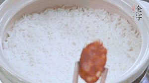 煮開后轉(zhuǎn)小火，當(dāng)米飯出現(xiàn)小孔時(shí)，鋪上金字麻辣香腸。