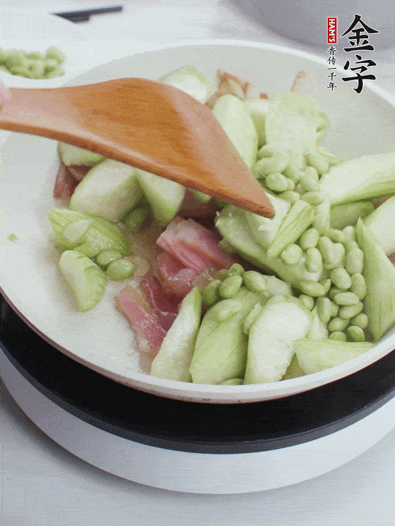 依次下絲瓜、青豆翻炒，炒至絲瓜打蔫縮小。