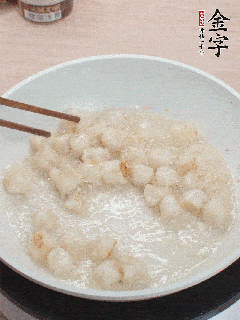 油溫4成熱，鮮貝蘸干淀粉下鍋煎，一面微黃后翻面。