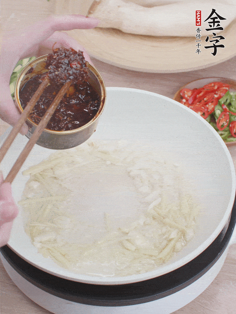 起鍋熱油，姜蒜、金字火腿干貝醬煸香。