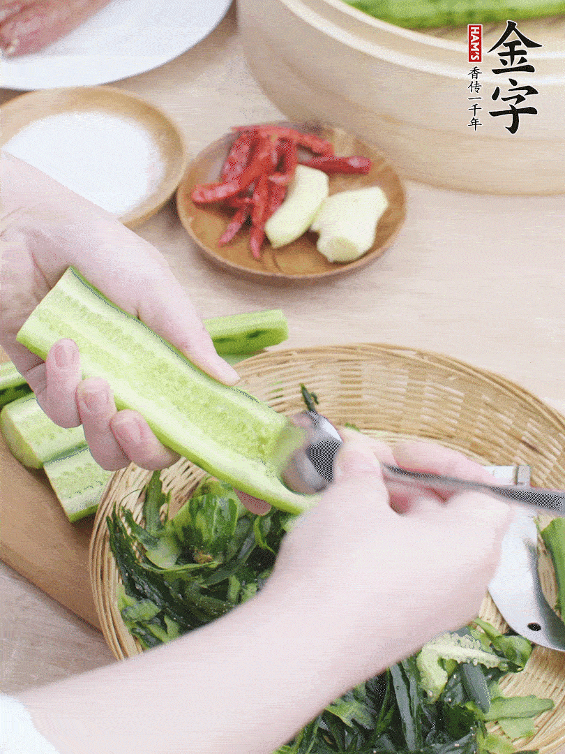 黃瓜削皮，對半切開，勺子挖去內瓤，斜刀切片。青蒜斜刀切段。