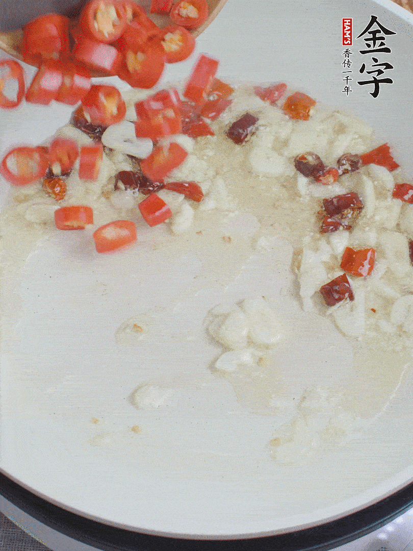 油6成熱，下蒜末、干紅辣椒煸炒，出香味后再放美人椒、香腸。