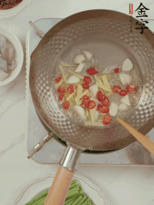 油7成熱時(shí)，下大蒜粒、姜絲、小米辣煸香。