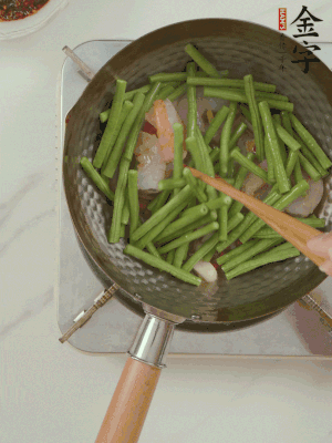 下掰好的缸豆段翻炒，略燜煮。
