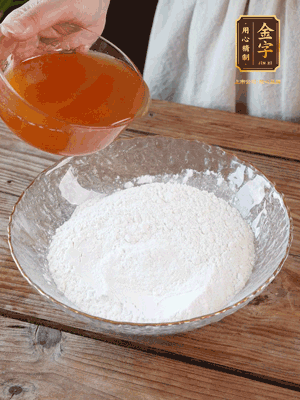 轉(zhuǎn)化糖漿、枧水、花生油攪拌均勻，加入面粉混合，醒發(fā)2小時。捏成23g一個的小球