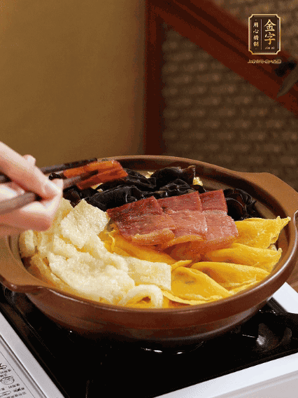 砂鍋底部鋪上娃娃菜，依次擺上肉皮、蛋餃、黑木耳、火腿